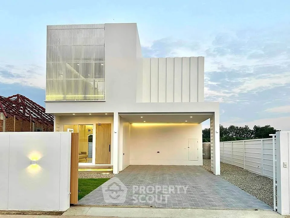 Modern minimalist white house with spacious driveway and sleek architectural design.