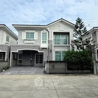 Elegant two-story house with modern facade and lush greenery in a serene neighborhood.