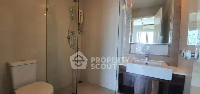 Modern bathroom with glass shower and sleek vanity in a contemporary apartment.