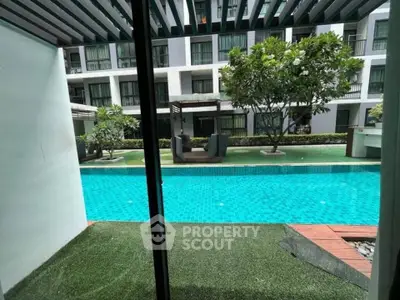 Luxurious condo with pool view, lush greenery, and modern architecture for serene living.