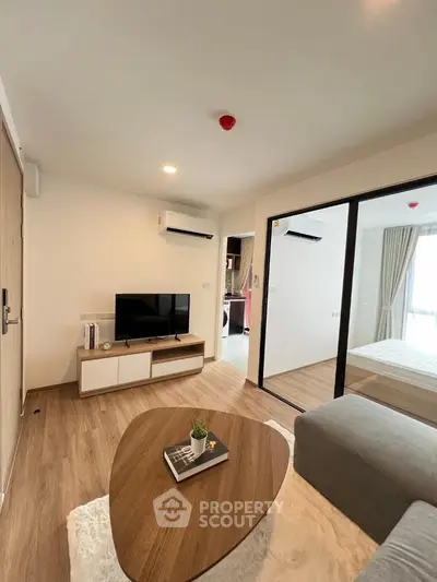 Modern living room with sleek design, wooden flooring, and cozy furniture in a stylish apartment.