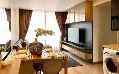 Modern living room with dining area and washing machine, featuring elegant decor and natural light.