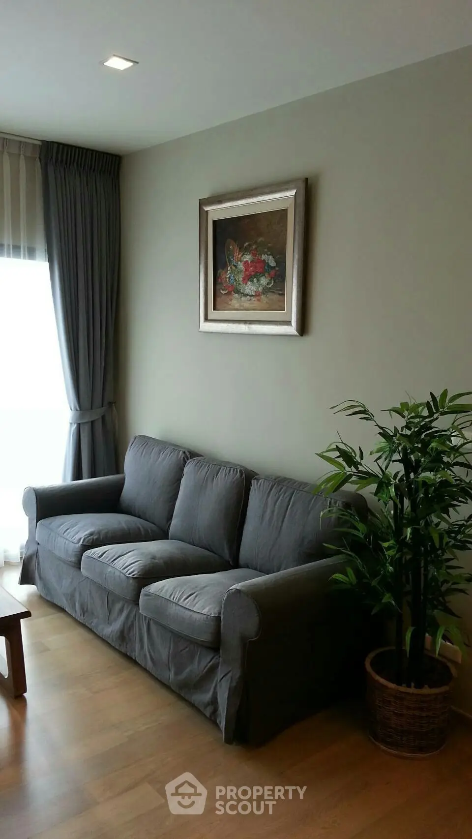 Cozy living room with gray sofa, wooden floor, and elegant decor