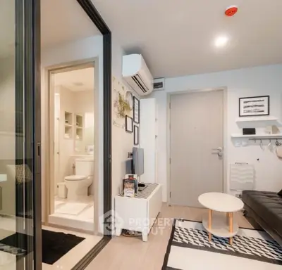 Modern apartment interior with living room and bathroom, featuring sleek furniture and contemporary design.
