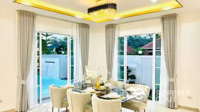 Luxurious dining room with elegant chandelier and pool view