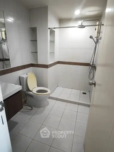 Modern bathroom with sleek shower and toilet in a minimalist design.