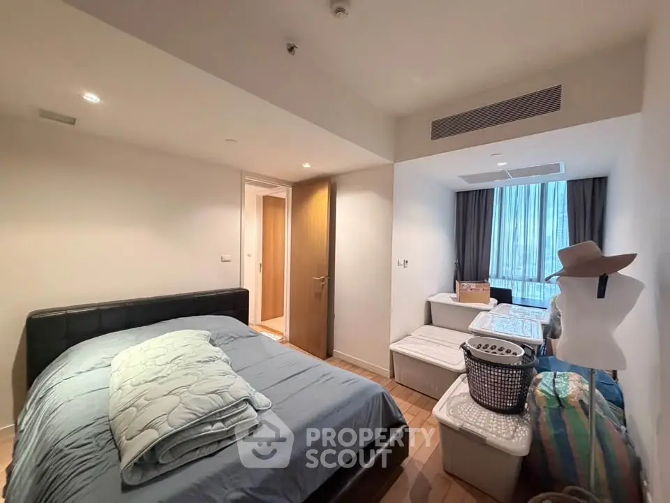 Cozy bedroom with modern decor and ample natural light in a stylish apartment.