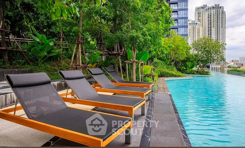 Luxurious poolside area with modern loungers and lush greenery in a high-rise residential complex.