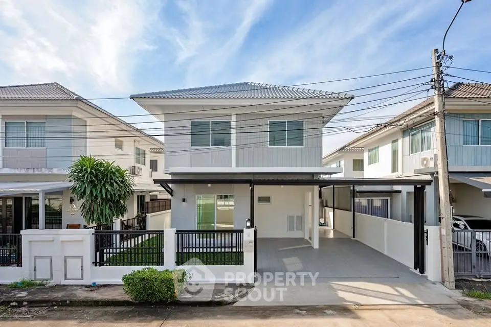 Modern two-story house with spacious driveway and manicured lawn in a suburban neighborhood.