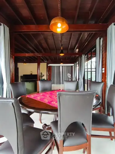 Elegant dining room with wooden ceiling and large round table, perfect for gatherings.