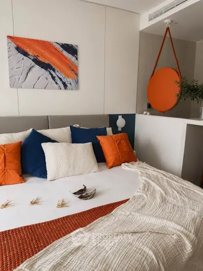 Modern bedroom with vibrant orange and blue accents, featuring stylish decor and cozy bedding.