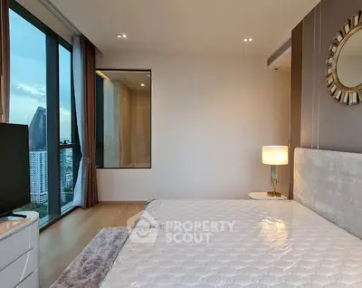 Modern bedroom with large window and city view, featuring elegant decor and cozy ambiance.
