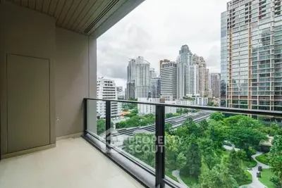 Stunning city view from modern high-rise balcony overlooking lush greenery and skyscrapers.