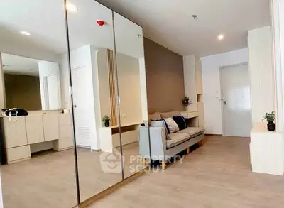 Modern living room with mirrored wardrobe and cozy sofa in stylish apartment.