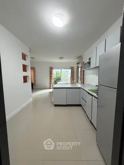 Spacious kitchen with modern appliances and open layout leading to a bright living area.