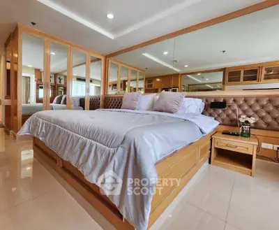 Luxurious bedroom with elegant wooden accents and plush bedding in modern apartment.
