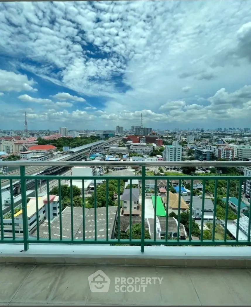 Stunning cityscape view from a high-rise balcony with clear blue skies.