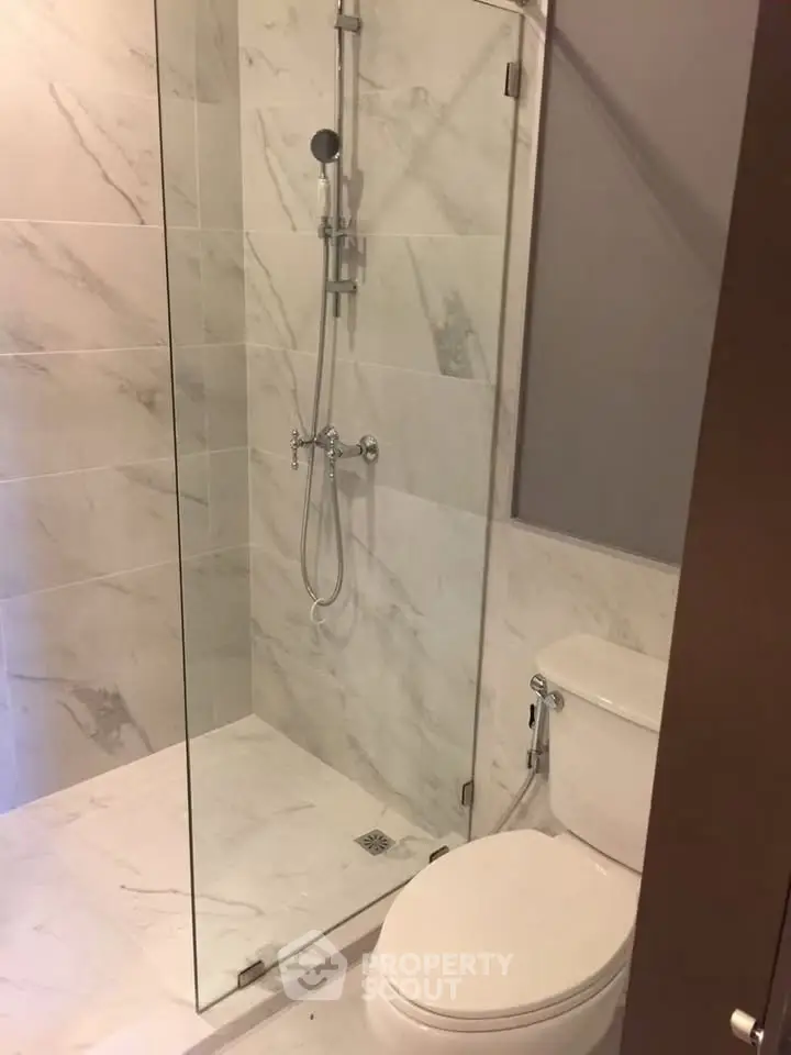 Modern bathroom with elegant marble tiles and glass shower enclosure