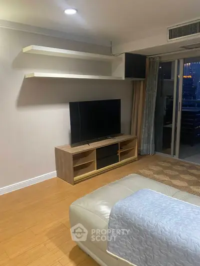 Modern living room with sleek TV stand and balcony access