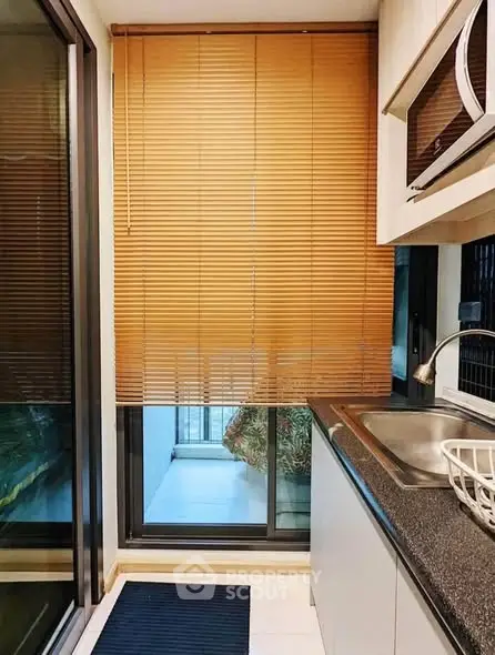 Modern kitchen with sleek design and large window blinds