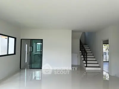 Spacious modern living room with sleek staircase and large windows