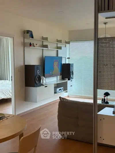 Modern living room with stylish shelving, large TV, and cozy seating area.