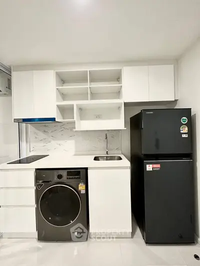 Modern compact kitchen with sleek appliances and white cabinetry