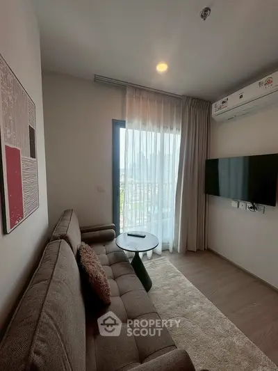 Cozy living room with modern sofa, wall-mounted TV, and balcony view