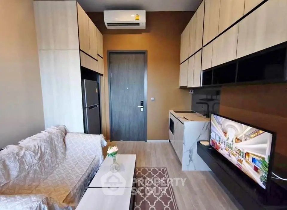 Modern living room with sleek furniture and integrated kitchen appliances in a stylish apartment.