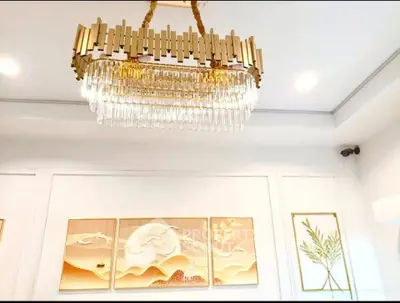 Elegant interior with modern chandelier and artistic wall decor in a luxurious setting.