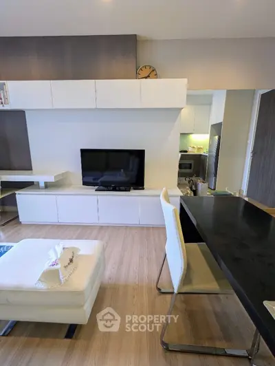 Modern living room with sleek furniture and open layout, featuring a stylish TV unit and dining area.