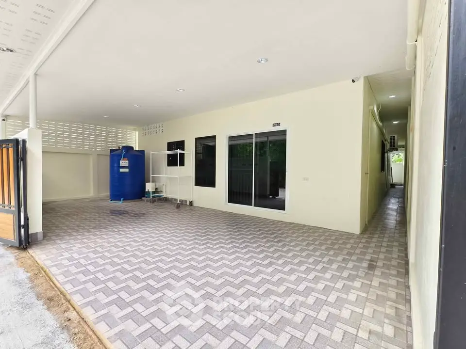 Spacious covered parking area with tiled flooring and storage space.