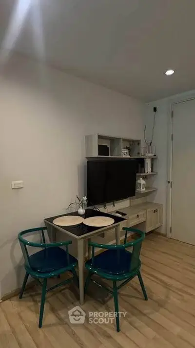 Cozy study nook with modern desk, chairs, and TV in stylish apartment.