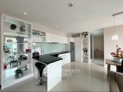 Modern kitchen with sleek white cabinets and breakfast bar in open layout