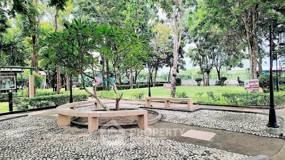 Serene garden area with lush greenery and seating, perfect for relaxation.