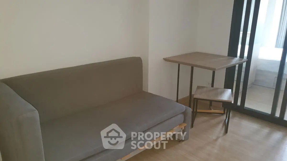 Cozy minimalist living room with gray sofa and wooden table, ideal for modern apartments.