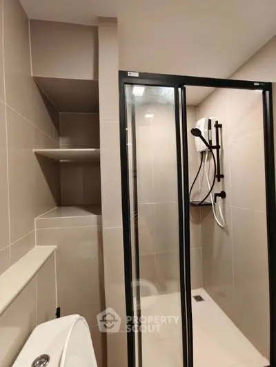 Modern bathroom with sleek shower enclosure and neutral tiles