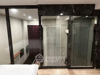 Modern bedroom with glass partition and sleek marble accents