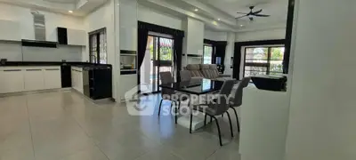 Spacious open-plan living and dining area with modern kitchen and large windows.