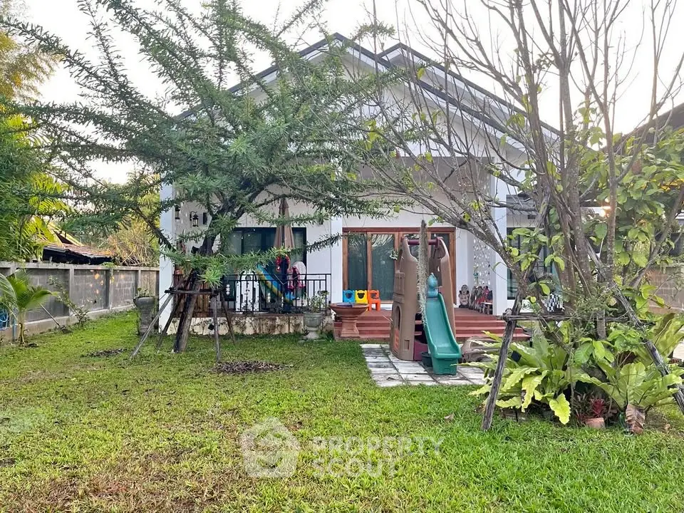 Charming family home with lush garden and children's play area, perfect for outdoor activities.
