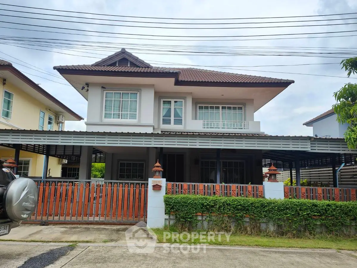 Charming two-story house with a tiled roof and spacious front yard in a serene neighborhood.