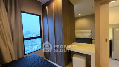 Modern bedroom with city view, featuring sleek furniture and ample natural light.