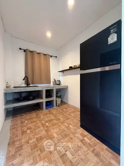 Modern kitchen with sleek black fridge and minimalist design