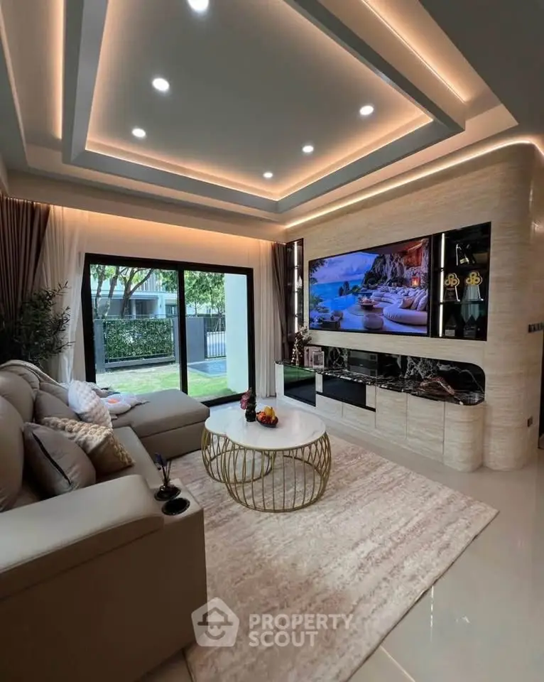 Luxurious living room with modern decor, large TV, and garden view through sliding doors.