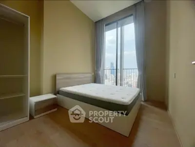 Spacious bedroom with large window offering stunning city view, modern minimalist design, and ample natural light.