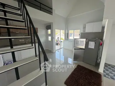 Modern open-layout kitchen with sleek staircase and natural light
