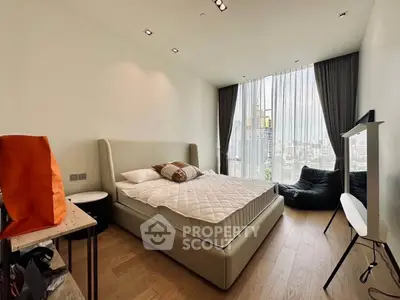 Modern bedroom with city view, featuring a stylish bed and floor-to-ceiling windows.