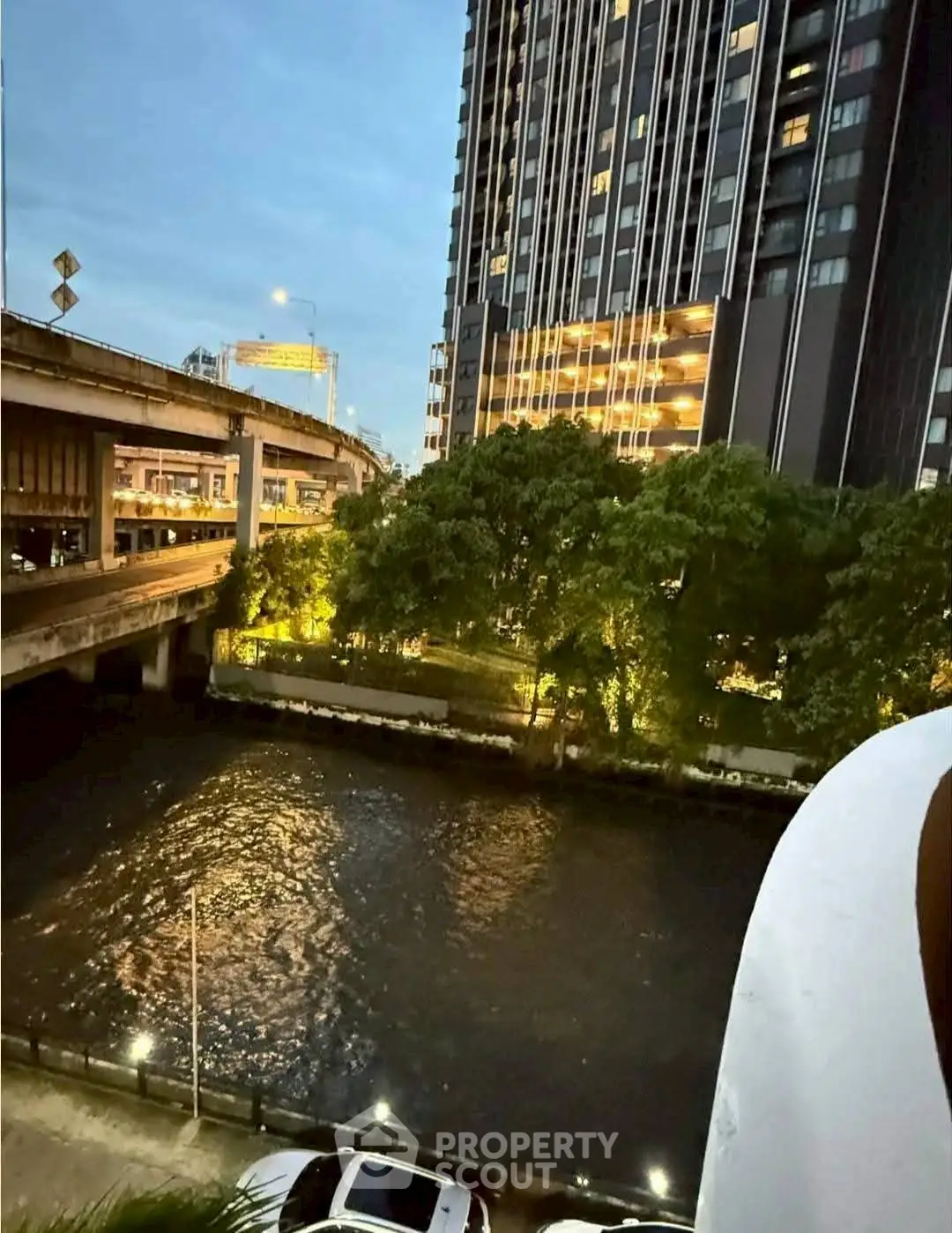 Stunning urban view with high-rise building and river at dusk, perfect for city living enthusiasts.
