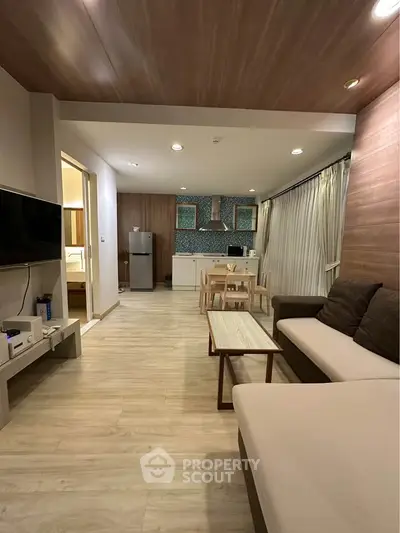 Modern open-plan living room with stylish kitchen and cozy seating area.