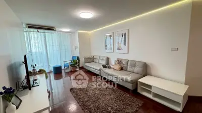 Spacious living room with modern decor and natural light, featuring a cozy seating area and stylish accents.